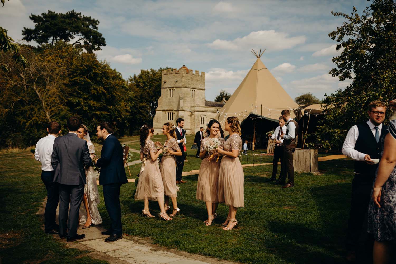 guests mingled at wedding with tipi in background