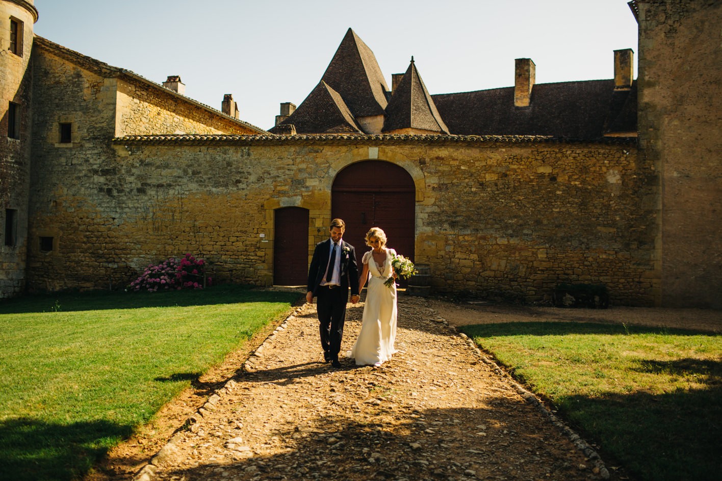bride and groom with chateau as backdrop