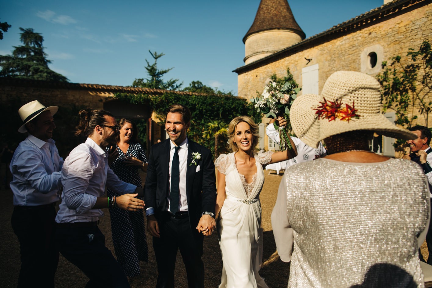 bride and groom making entrance to outdoor dinner at Chateau de la Bourlie
