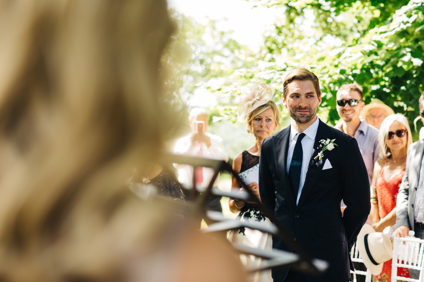 Groom seeing bride for first time at outdoor wedding ceremony
