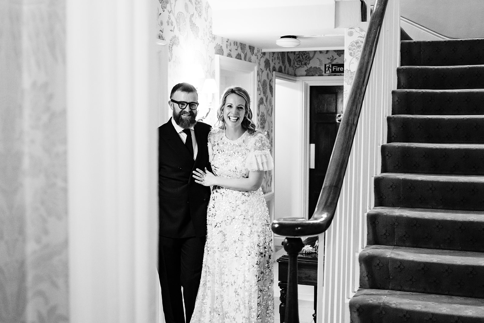 bride and groom walking down the hall together after their wedding at hambleton hall 