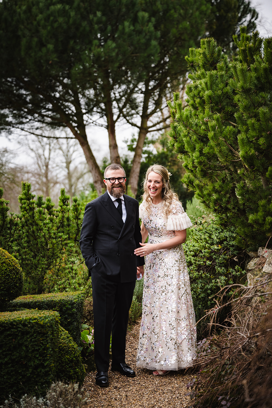Bride and groom in the gardens at hambleton hall laughing