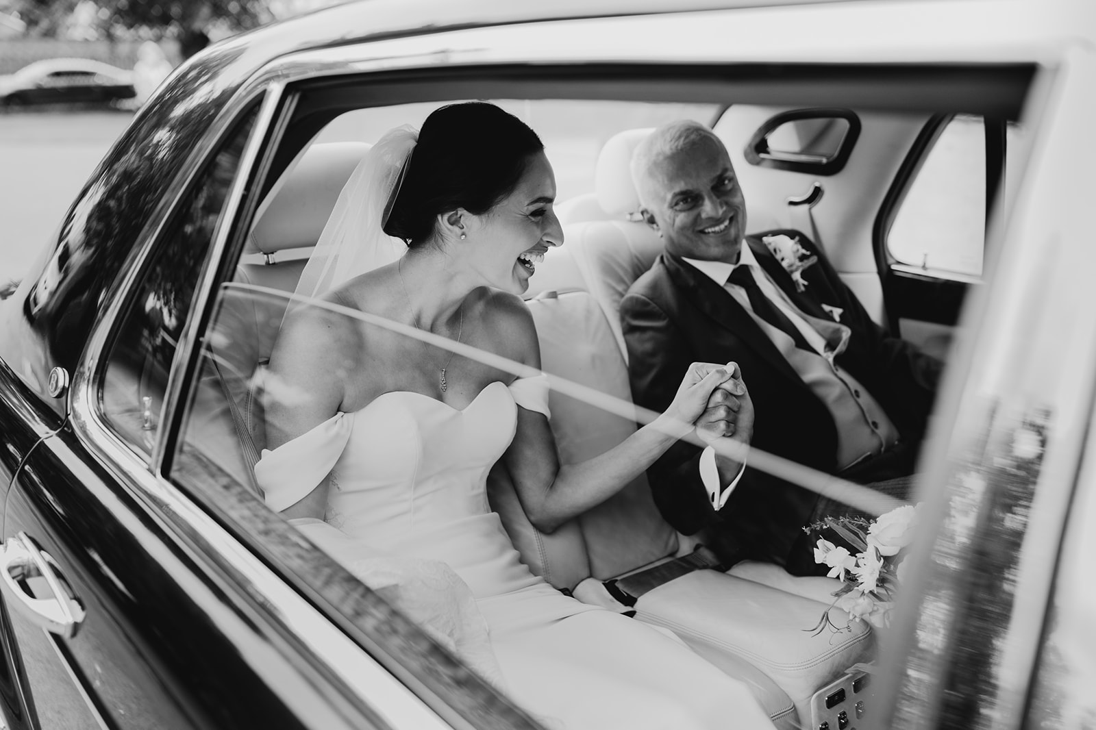 Natural wedding photograph of a bride and dad sharing a heartfelt moment in the car before ceremony.