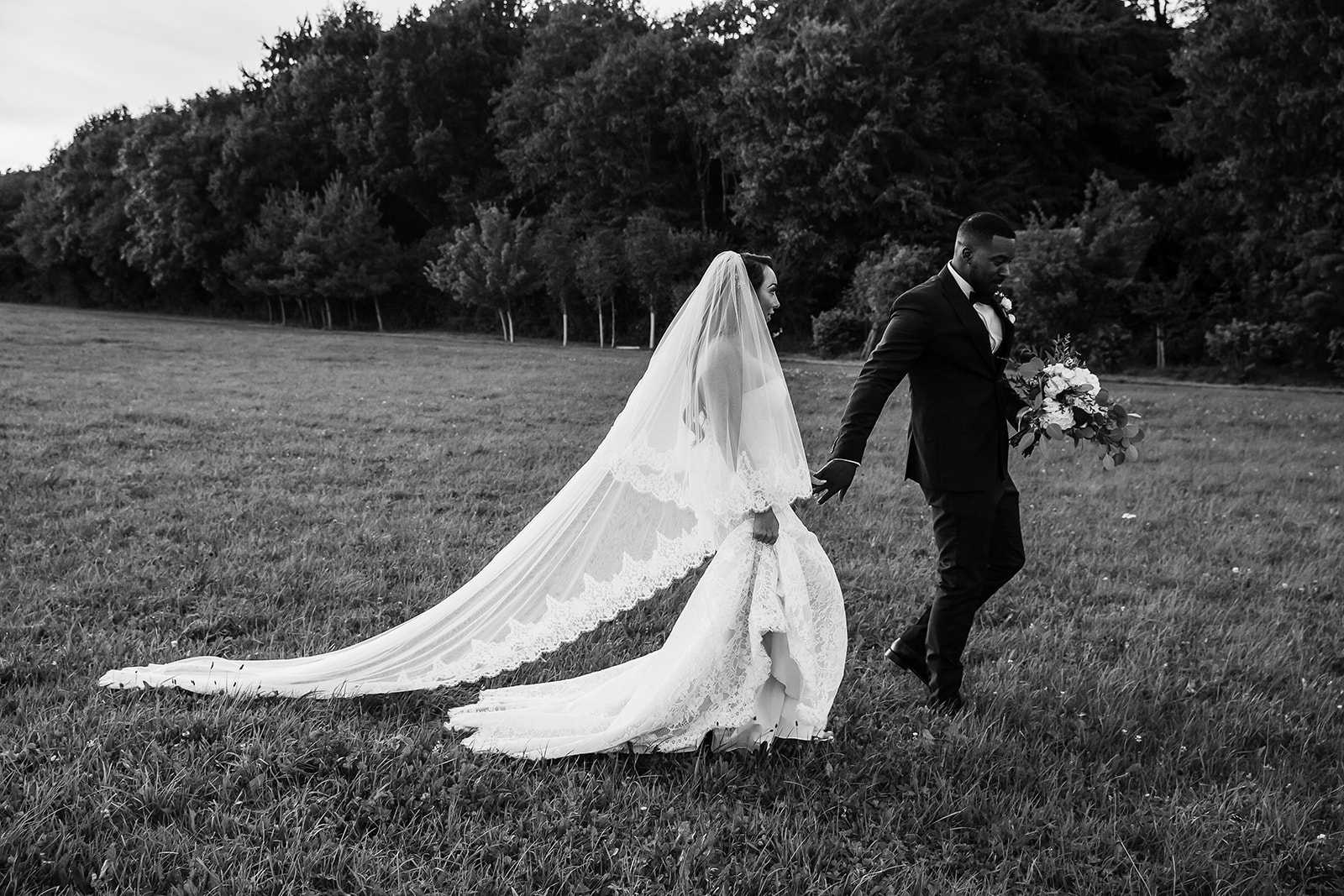beautiful wedding veil couple walking hand in hand at Cripps barn in the cotswolds