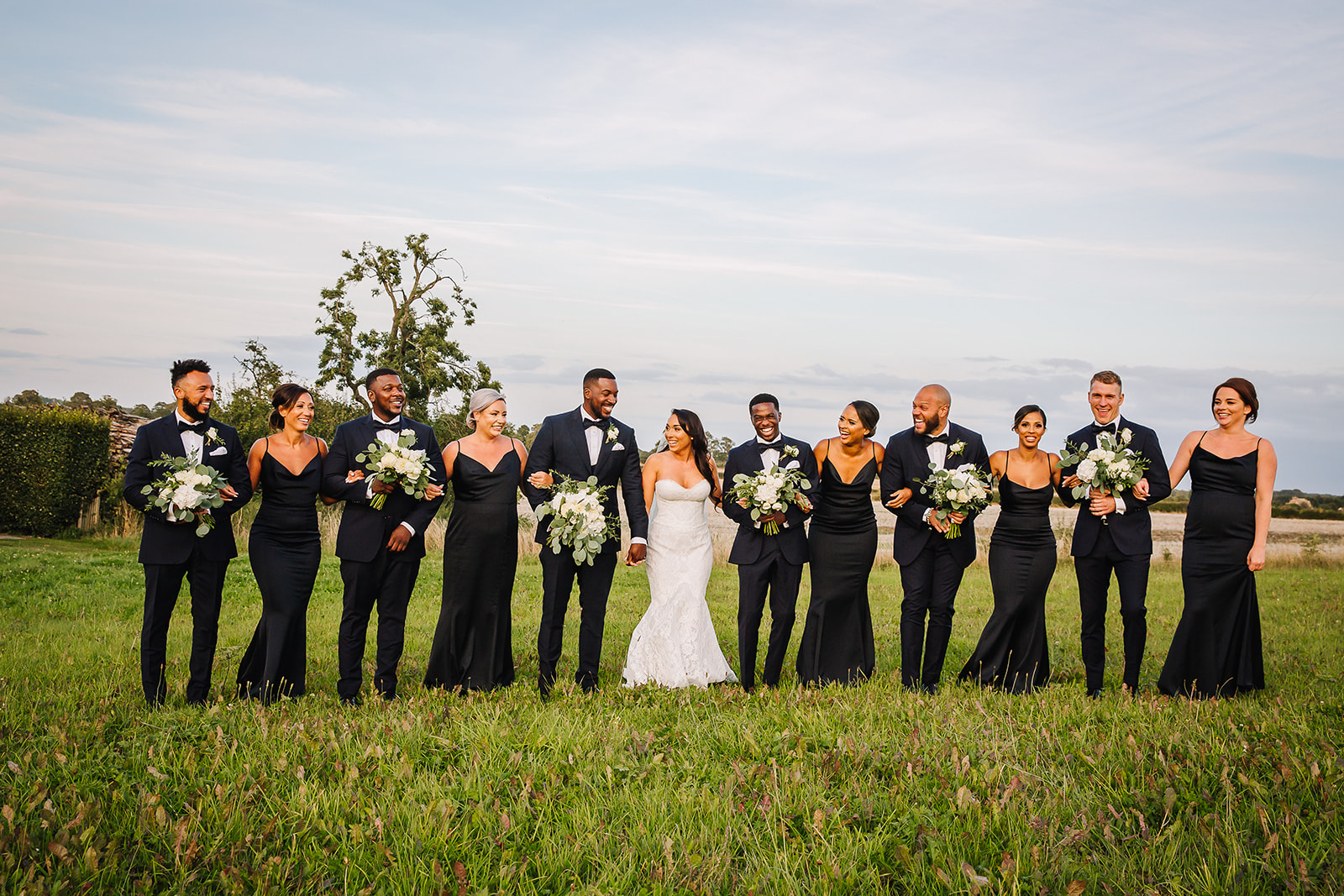 bridal party in tuxedos and black dresses