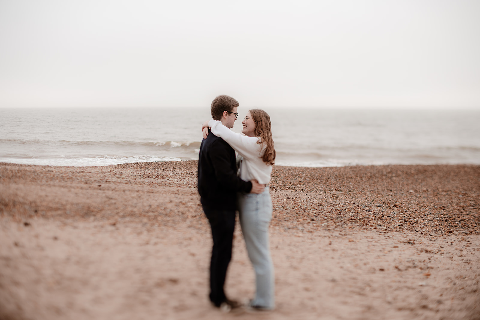 Couple cuddle each other, their noses close together, on Highcliffe Beach