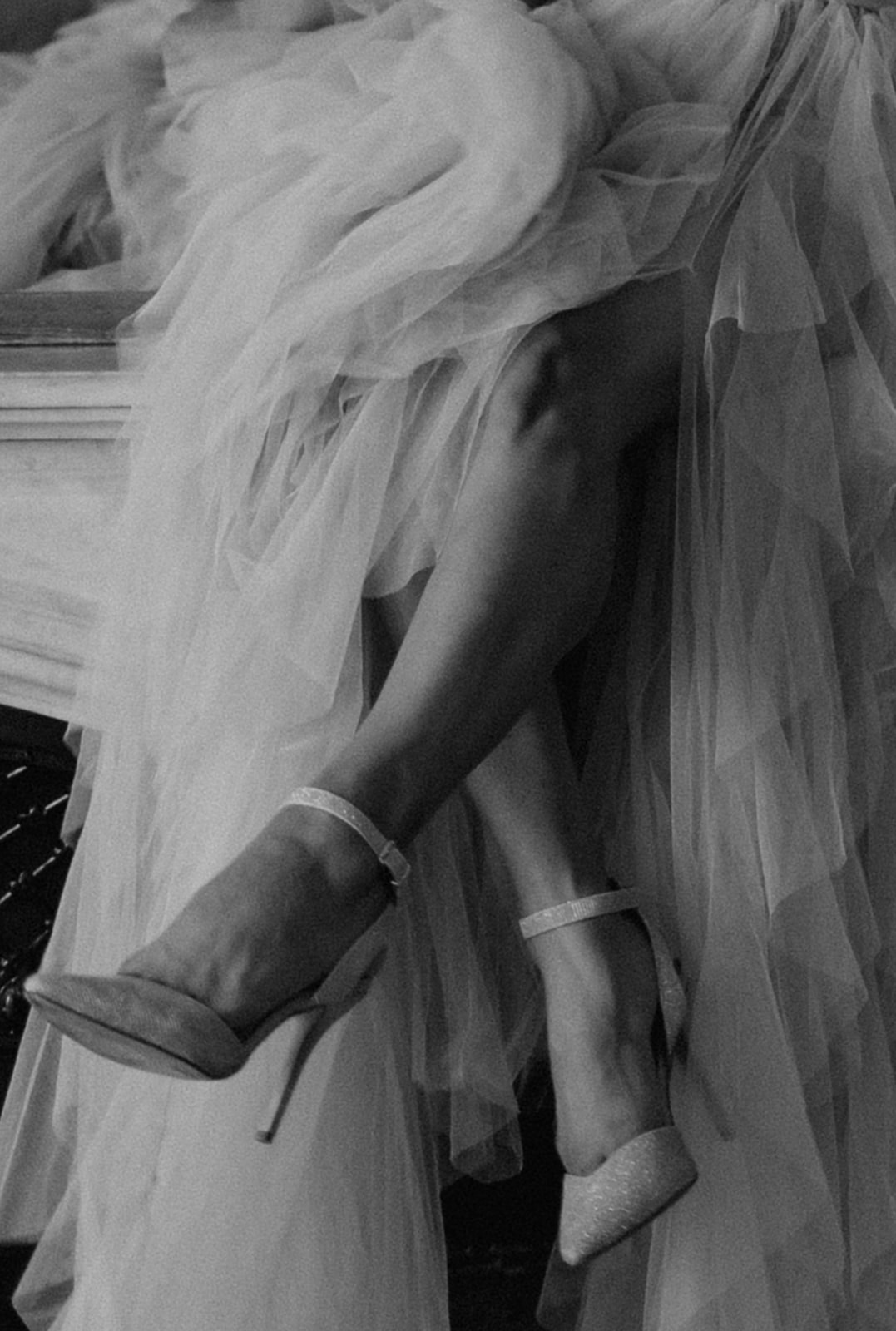 Black & white close up of stiletto heels and tulle dress