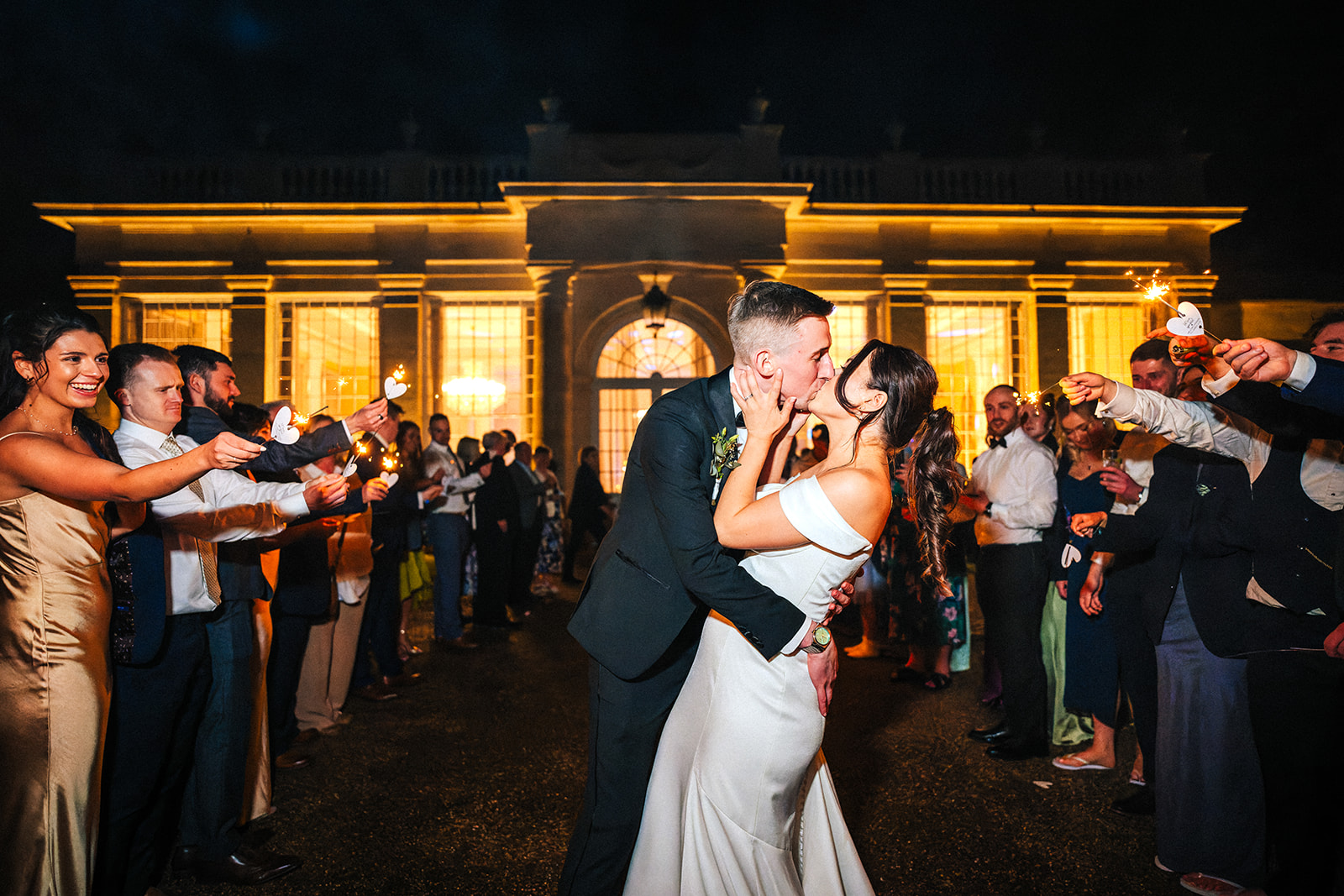 bride and groom kiss during their sparkler exit